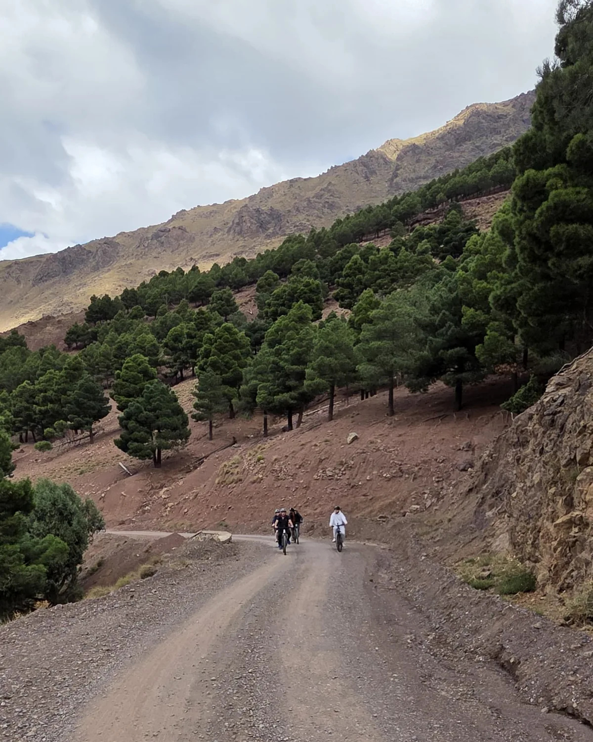 Cyclists riding through scenic Atlas Mountain roads in Morocco